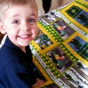 Little Boy estatic after getting his John Deere quilt!